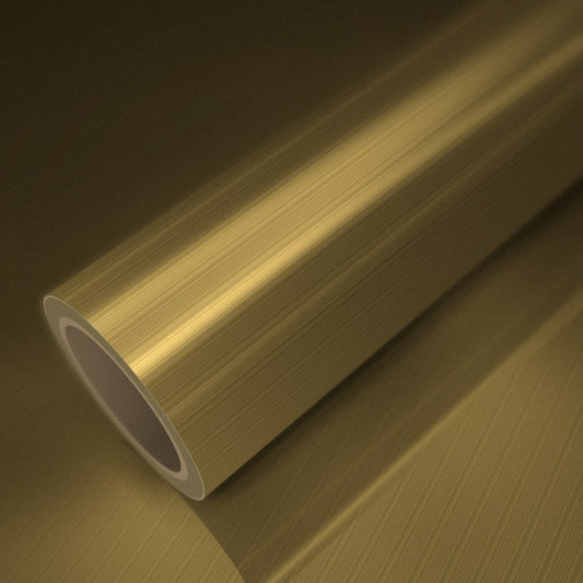 Rouleau de vinyle or brossé posé sur une feuille du même vinyle