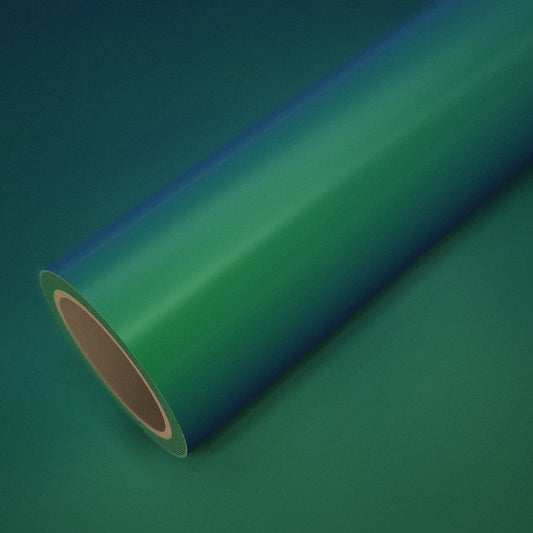 Rouleau de vinyle vert magique (color flip) posé sur une feuille du même vinyle